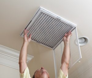 An HVAC professional changing an air filter