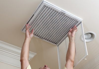 An HVAC professional changing an air filter